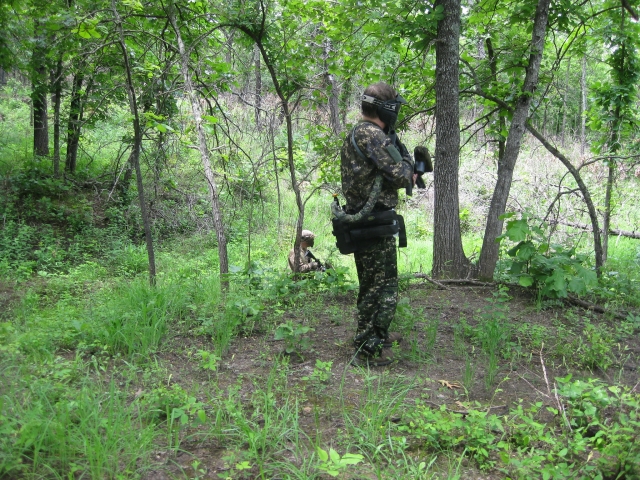 Joueur de paintball portant un costume de camouflage prêt à tirer 