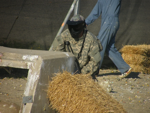  Paintballspieler im Tarnanzug ist dabei, 300 Paintballs zu schießen 