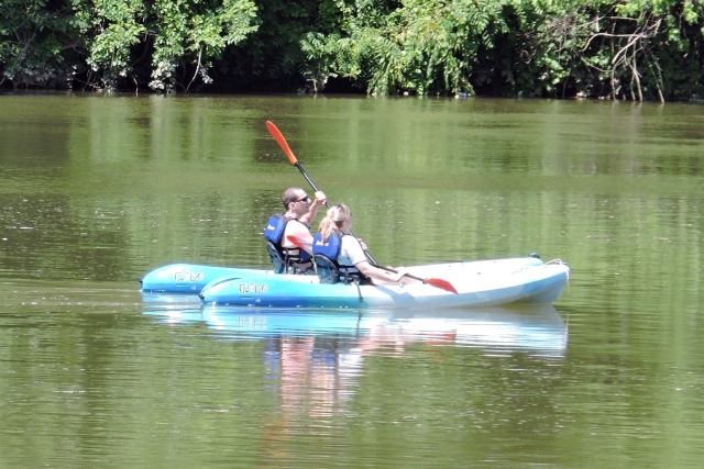 Two people having fun having fun kayaking on blue kayak