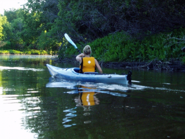 Woman wearing yellow buoyancy aids kayaking