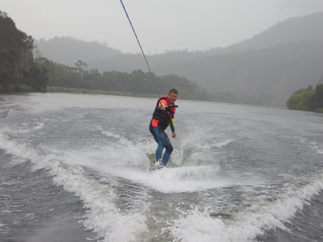  garoto em ajuda vermelha de flutuação praticando wakeboarding