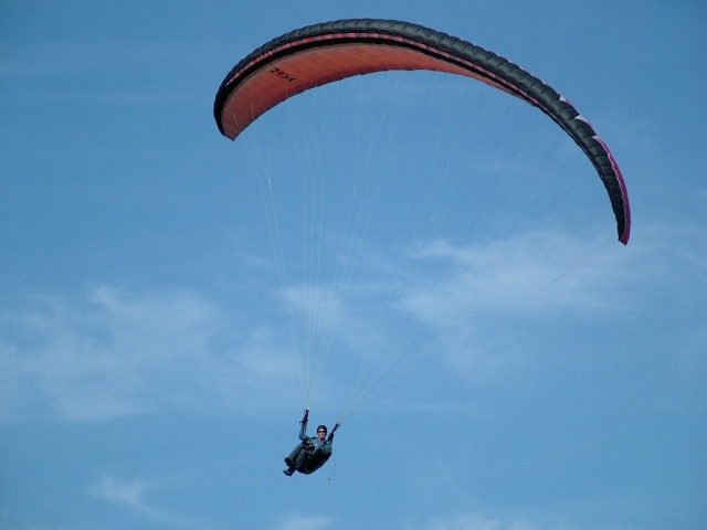 Man in red flying paragliders