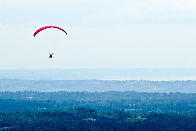 Person on a red flying paraglider