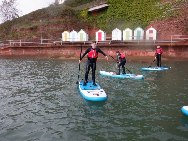 p-73997-three-young-boys-wearing-red-buoyancy-aids-and-black-wetsuits-doing-paddleboarding_16418095071983.jpg