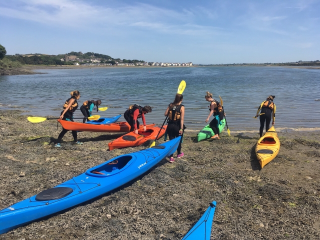  Groupe de personnes emmenant les kayaks à l'eau afin de faire notre expérience de kayak tandem