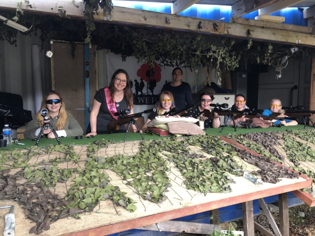 Group of gril friends wearing protective glasses about to shoot their rifles