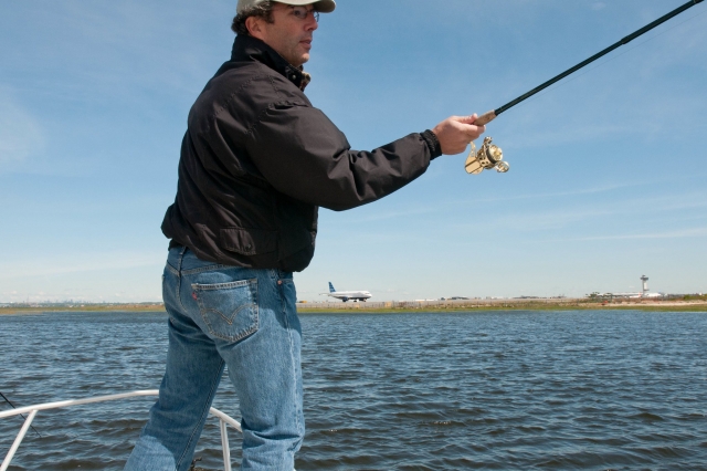  Hombre con chaqueta negra y gorra pescando 