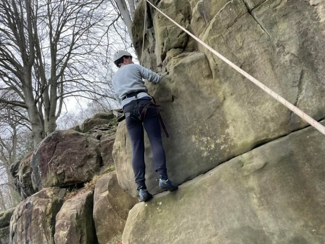  Men em suéter cinza e capacete branco escalando 