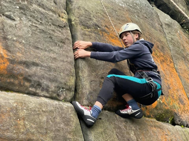  menino usando suéter preto e capacete branco escalando 