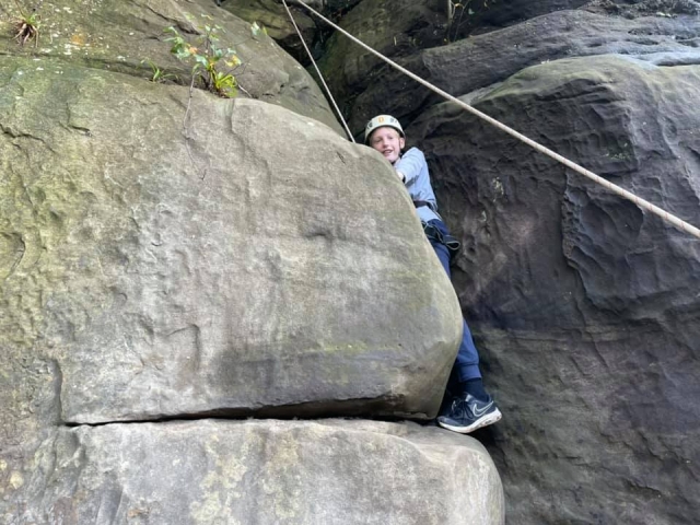  garoto jovem usando suéter cinza e capacete branco escalando 