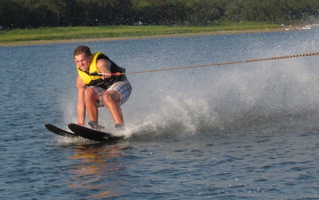  Garçon portant des aides à la flottabilité jaunes pour le ski nautique