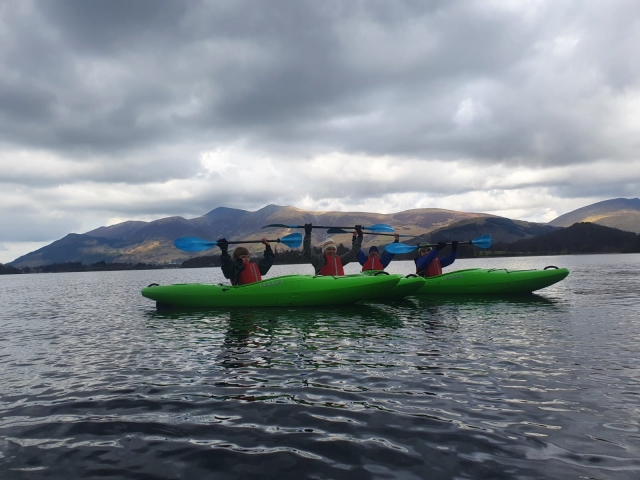 Persone che indossano giubbotti salvagente rossi celebrano la loro esperienza in kayak 