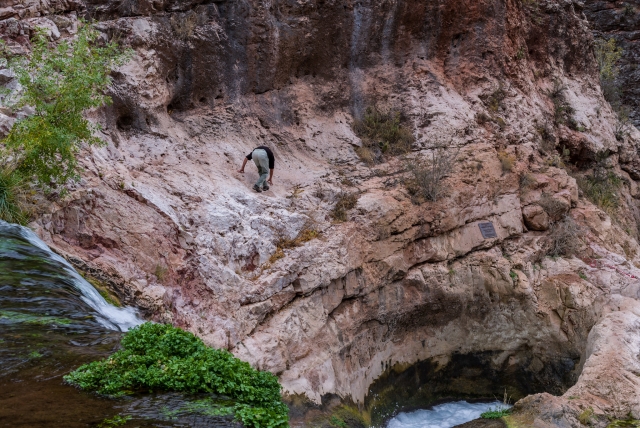 Gorge d'homme marchant et eau au fond 