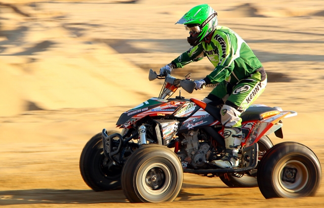  Conductor con casco verde y traje verde durante su sesión de quads 