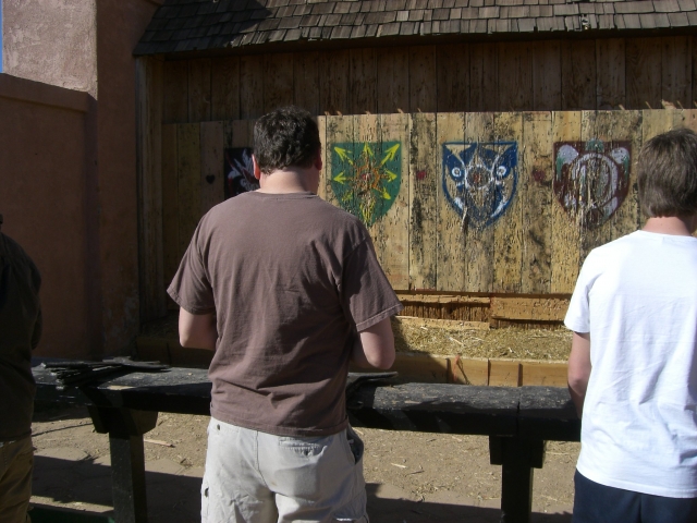 Two friends wearing grey and white t-shirts about to start their axe throwing session