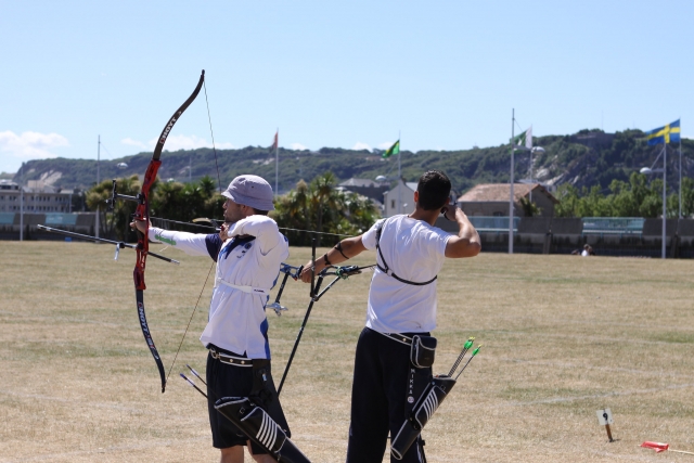 Two boys wearing white t-shirts doing archery