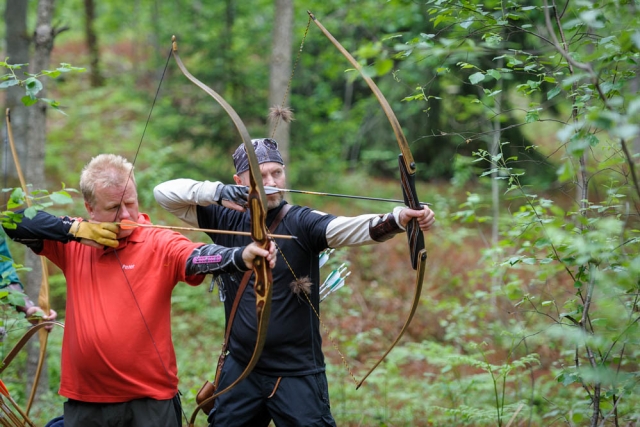 Man in red t-shirt and man in black t-shirt doing archery