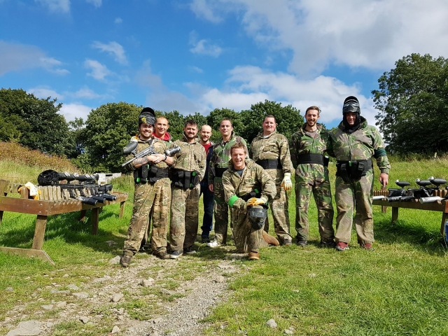 Personnes portant des combinaisons de camouflage se préparant à jouer au paintball 