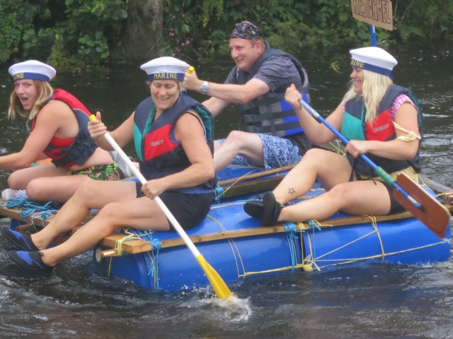  Des gens s'amusant, souriants, portant des aides à la flottabilité rouges et bleues pendant leur course de rafting 