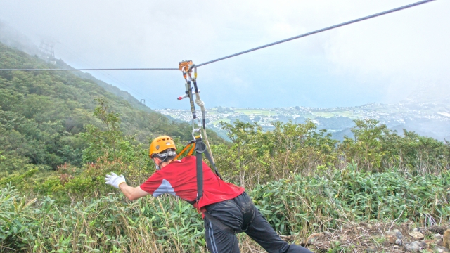 Man wearing yellow helmet and red t-shirt during his zip-lining experience