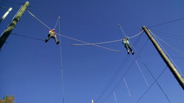  Garçon et fille portant un casque rouge l'air marchant sur des obstacles et des cordes en bois