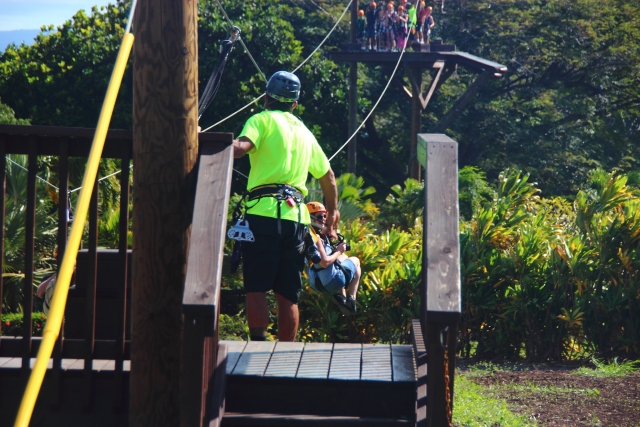 Personas preparándose, usando cascos, para divertirse durante una aventura en tirolesa