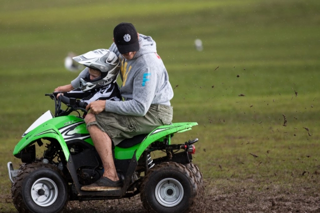  Un ragazzino che indossa il casco si gode la sessione in quad e guida con l'istruttore 