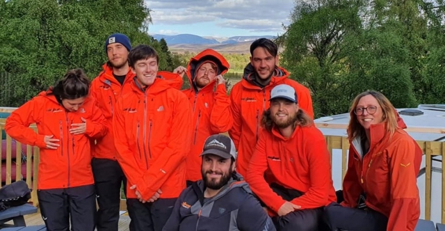  Amici che indossano un maglione arancione in procinto di fare un'escursione intorno alla montagna 