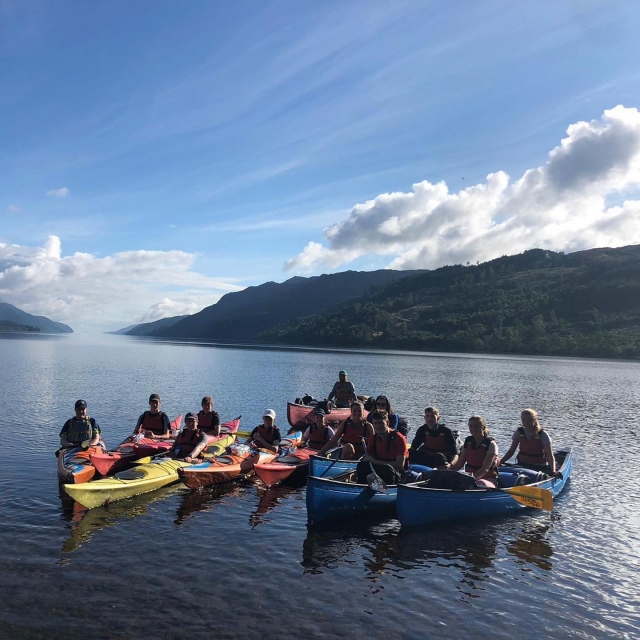  Différents groupes de personnes se préparant à faire du canoë autour en portant des aides à la flottabilité rouges