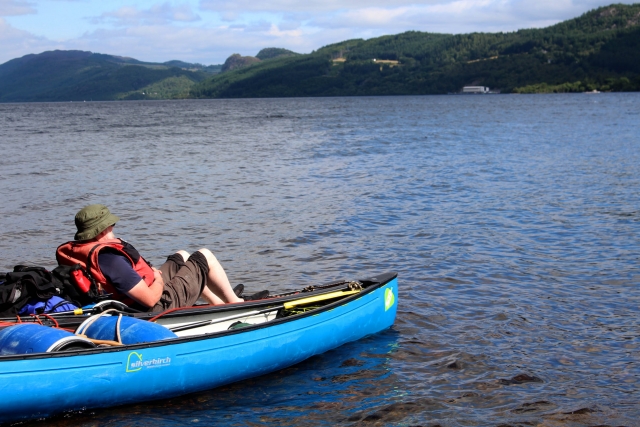 Man wearing green hat and red buoyancy aids enjoying the view during his kayaking experience