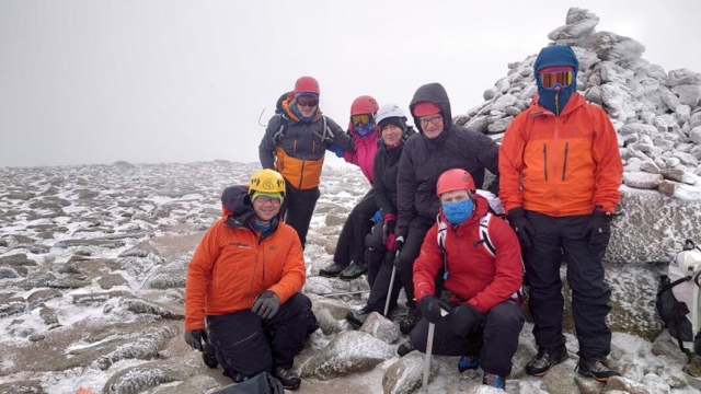  7 个人在本尼维斯山徒步旅行时穿着登山服 