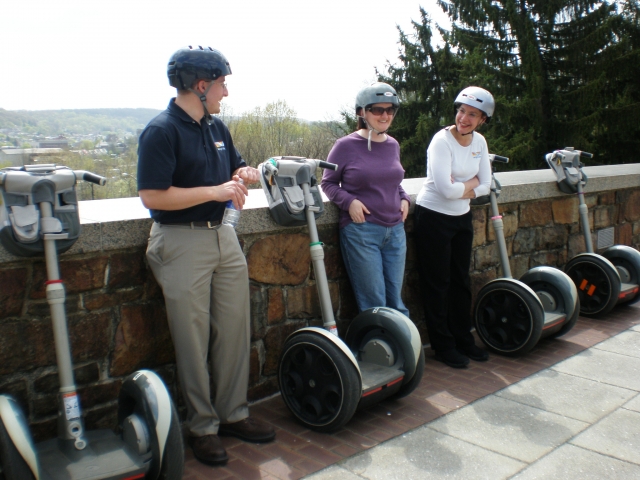  Tre persone che indossano caschi neri, blu e bianchi che riposano dopo la loro avventura in segway