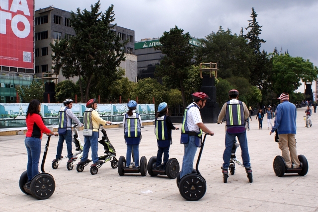  Grande gruppo di persone che indossano caschi blu e rossi durante la loro esperienza in segway e vanno al parco 