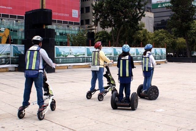  Quattro amici che indossano caschi blu fanno segway e vanno al parco 