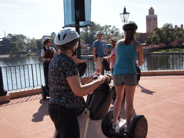  Donne che indossano caschi bianchi e neri che fanno un giro in segway intorno al lago 