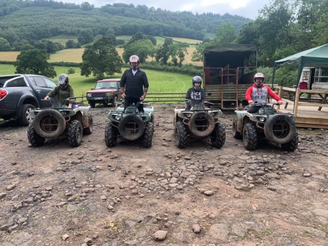  4 hommes portant des casques rouges et noirs se préparant à profiter de leur séance de quads 