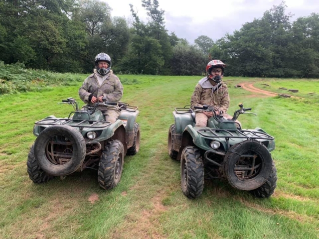  Deux amis portant des casques noirs et des combinaisons camouflage lors de leur séance de quads