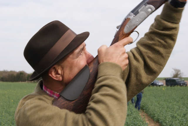 Man with hat aiming and shooting
