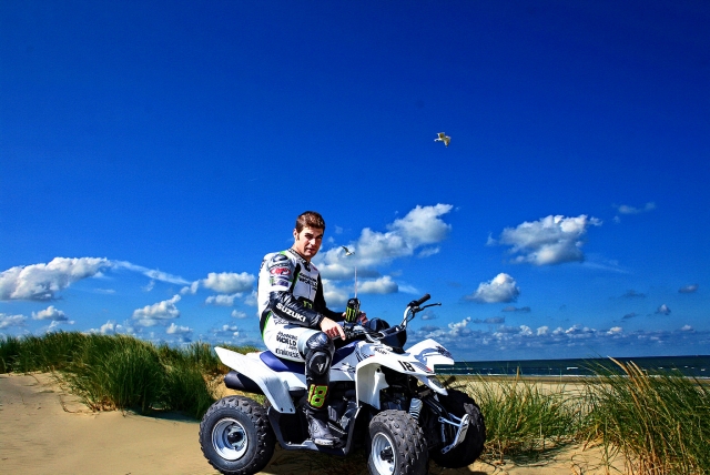  Jeune garçon portant une combinaison de conduite et conduisant un quad autour de la forêt et de la mer au bord 