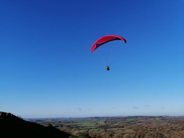 homme volant avec un parapente rouge
